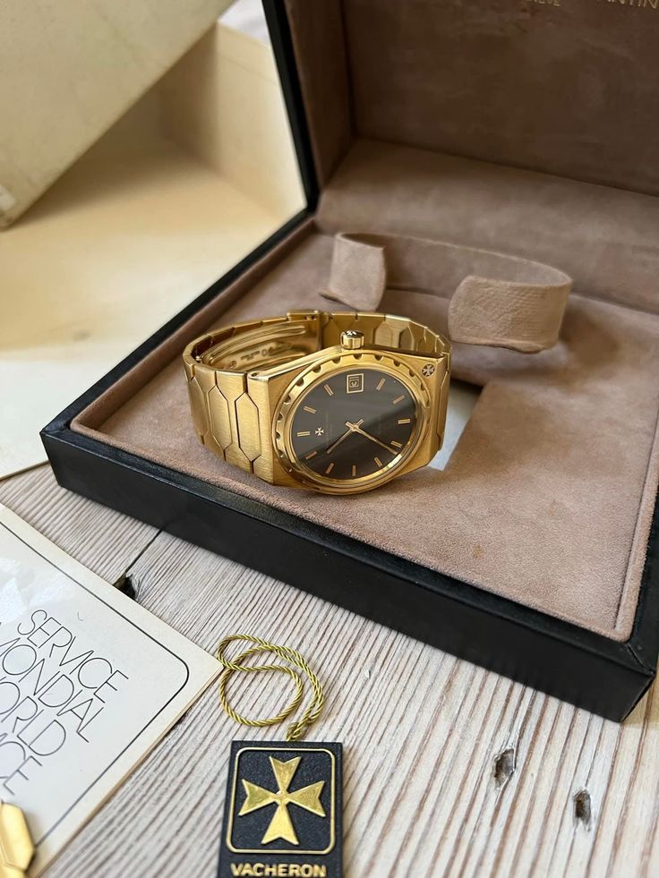Montre Vacheron Constantin en or jaune à cadran noir, posée dans son écrin d'origine